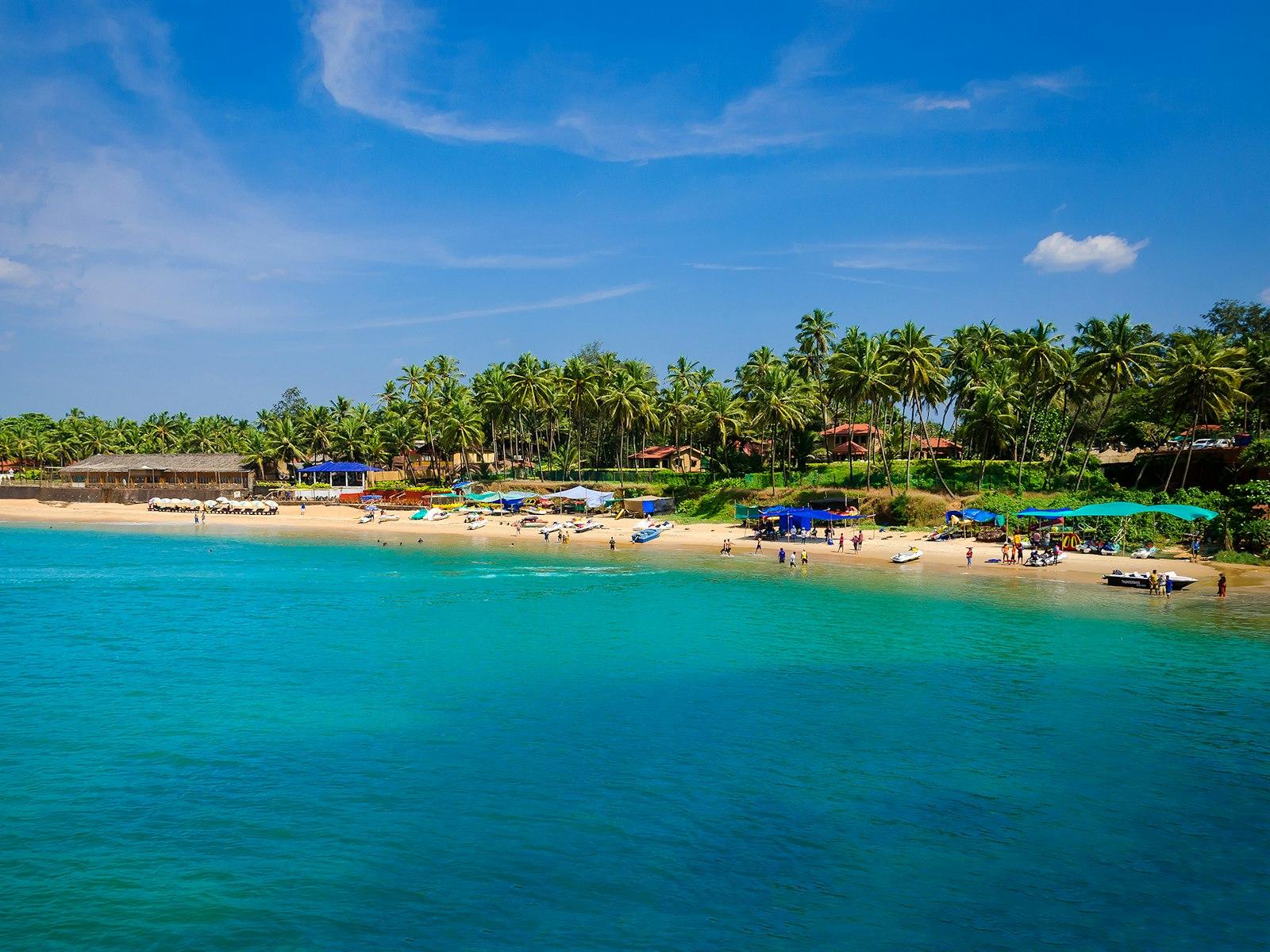 Sunlit sandy beach and blue sea in Goa