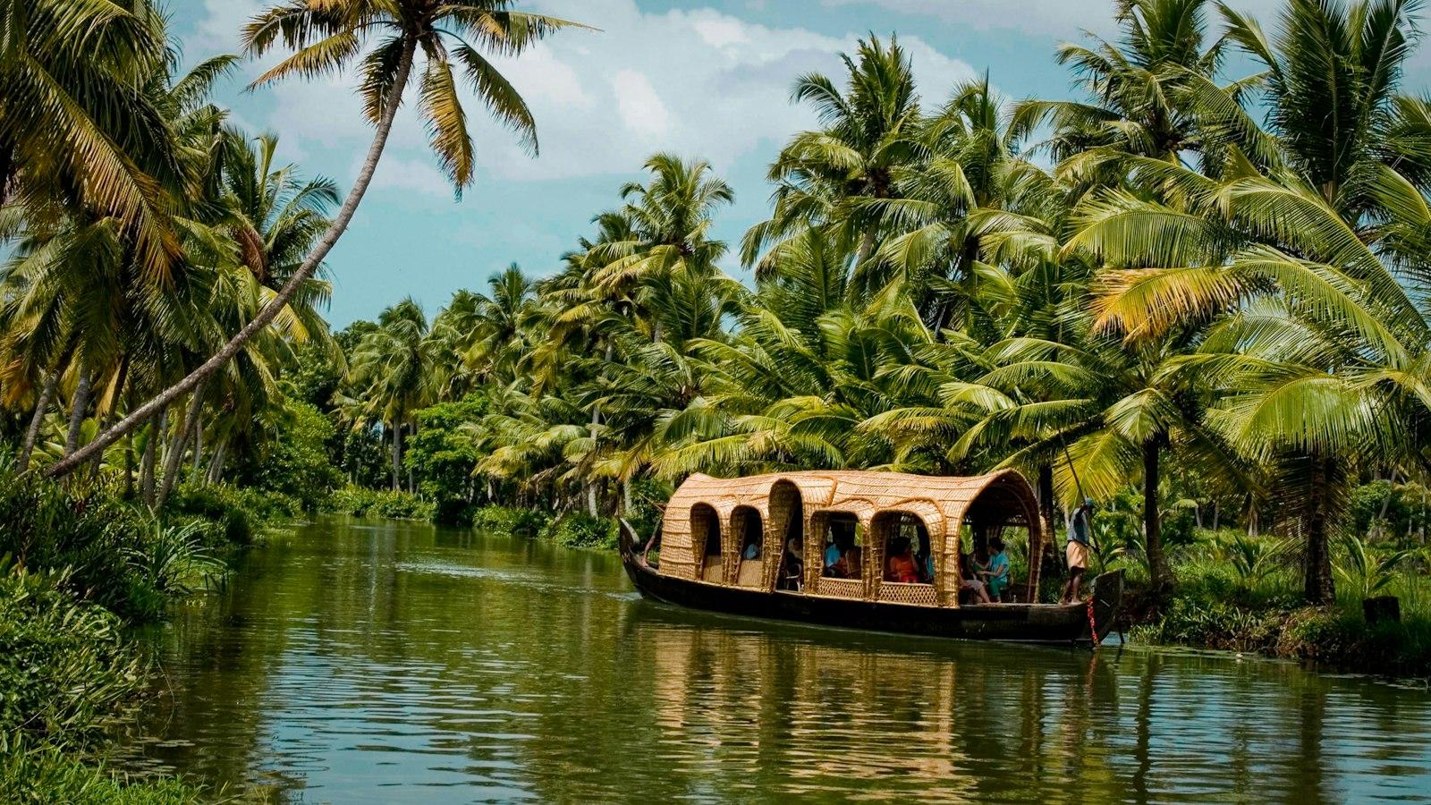 Houseboat drifting through the green backwaters of Kerala