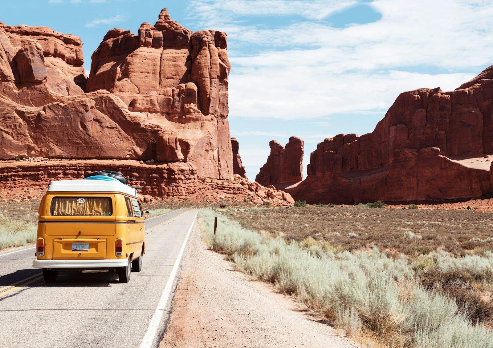 Vintage van parked on an open road through red rock desert